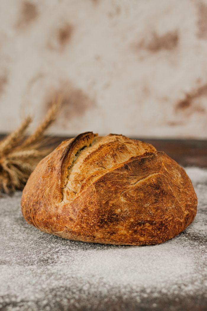 Close-up of a rustic artisan bread loaf on a flour-dusted surface.